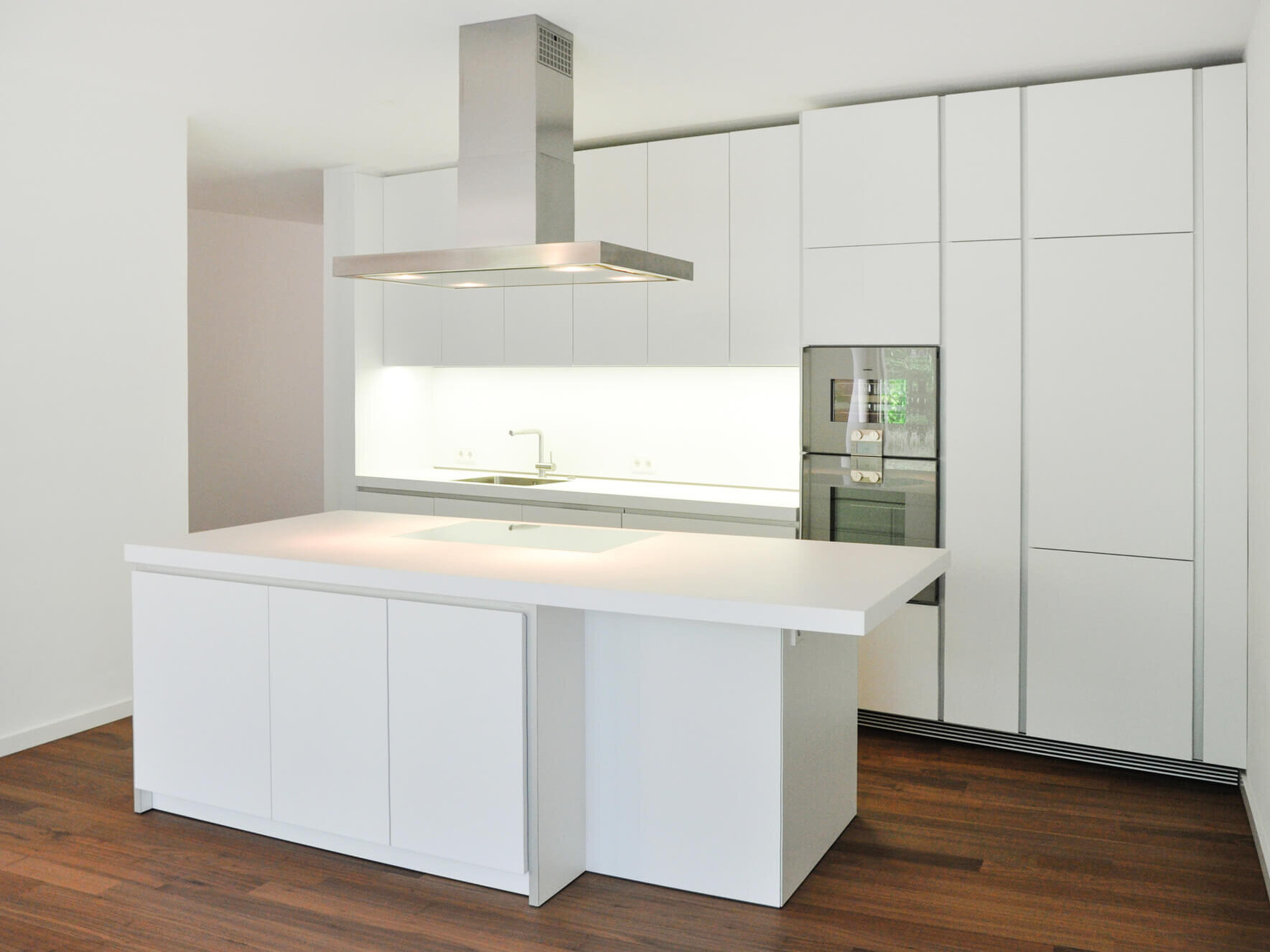 Weiße Einbauküche mit Kochinsel in Wohnung A4.45 im Neubau Hofstatt, München