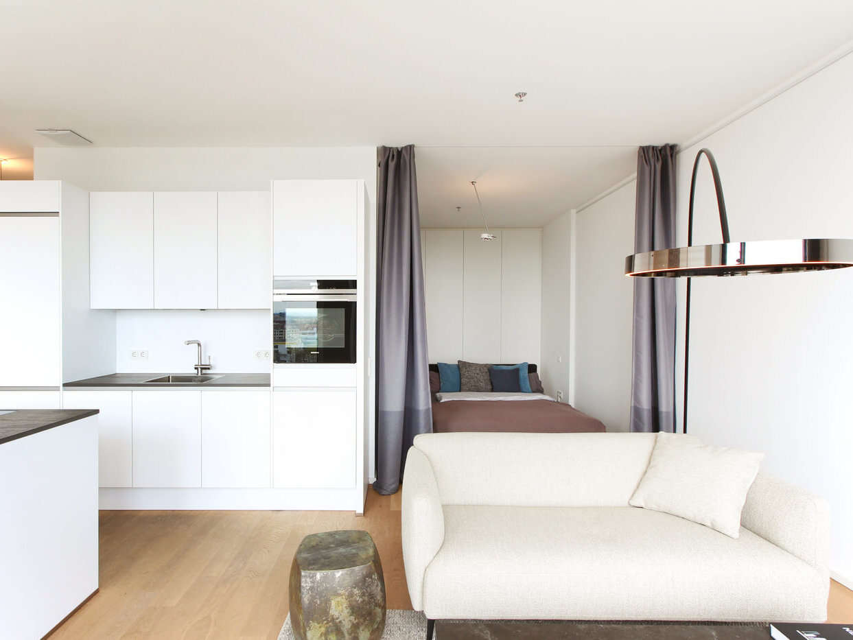 Küche und Sofa vor Schlafnische der FRIENDS Wohnung L4.10 in München-Neuhausen