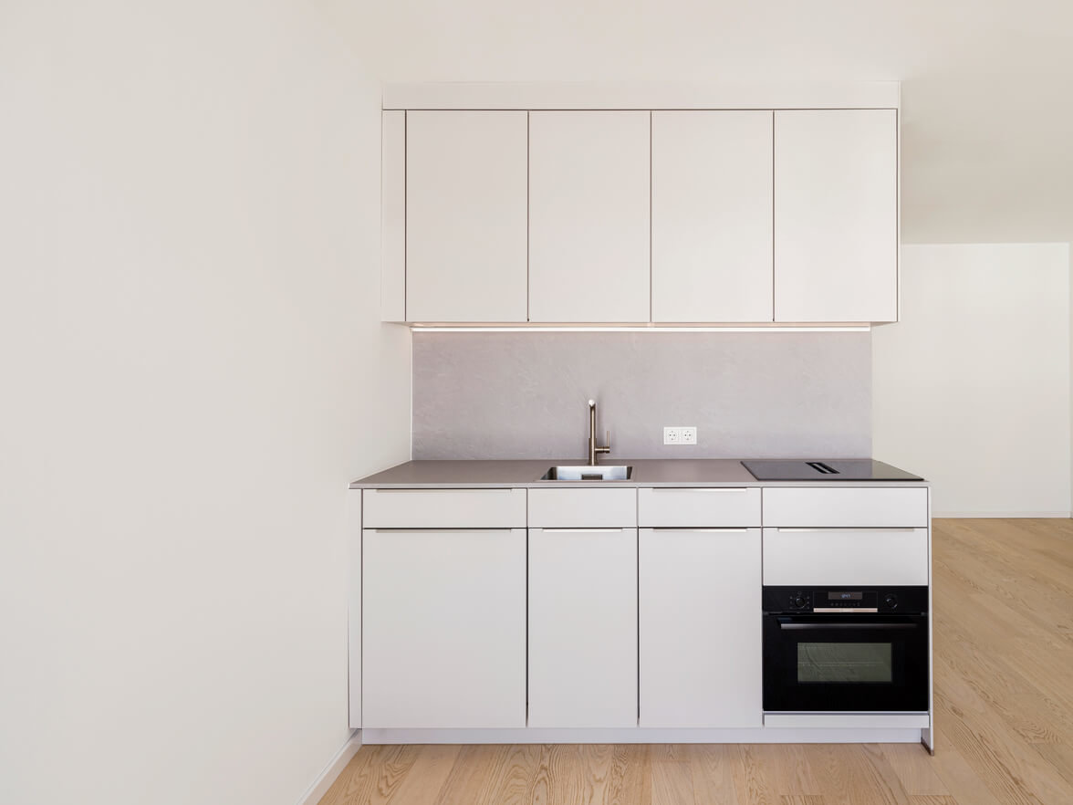 Einbauküche mit weißen Fronten in Apartment A.108 im Neubau Van B in Schwabing