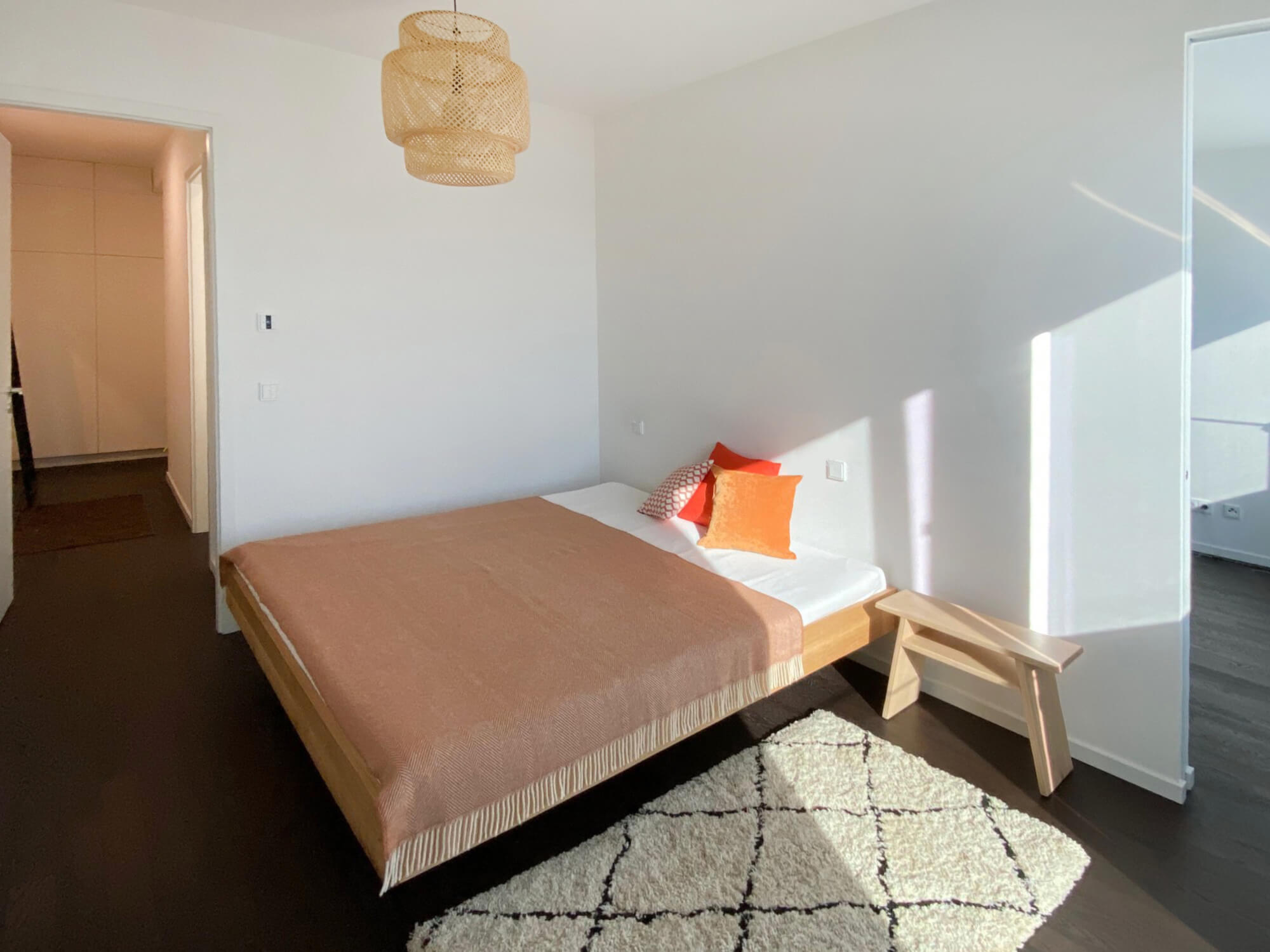 Schlafzimmer Mietwohnung E.38 WAVE Berlin-Friedrichshain mit Bett, Blick ins Bad