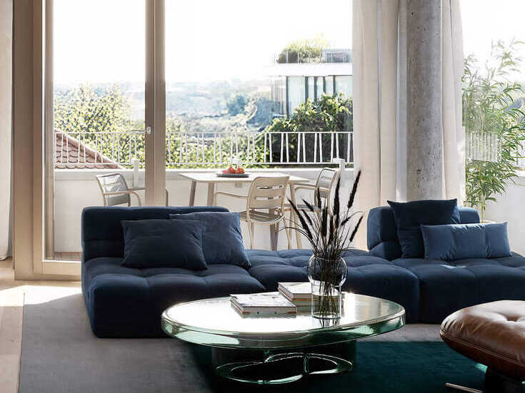 Wohnbereich mit Sofa, Tisch und Loggia im Neubau Haus Claude in Untergiesing