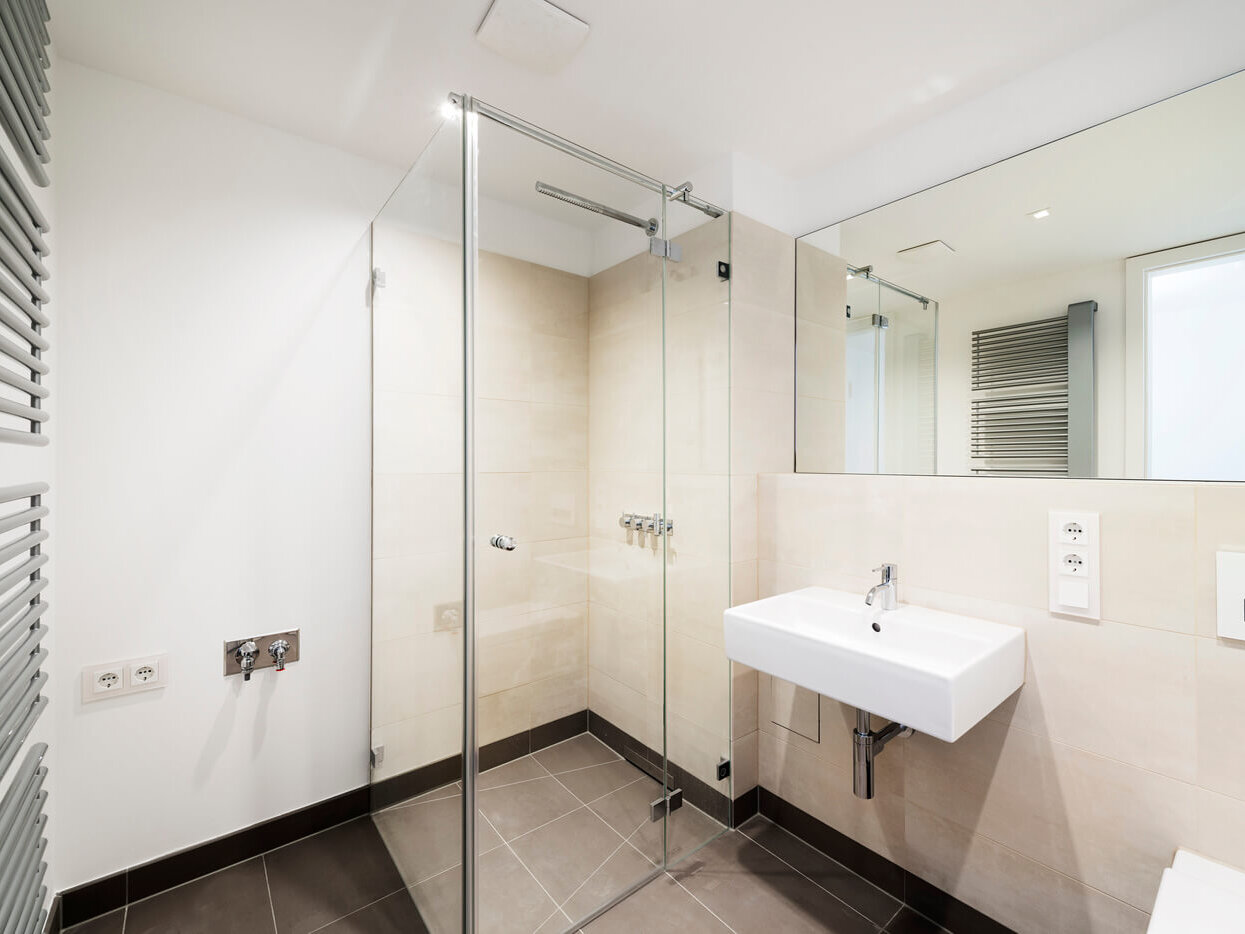 Bad mit Glasdusche und Spiegel in Wohnung W.33 im Neubau K63, München Schwabing