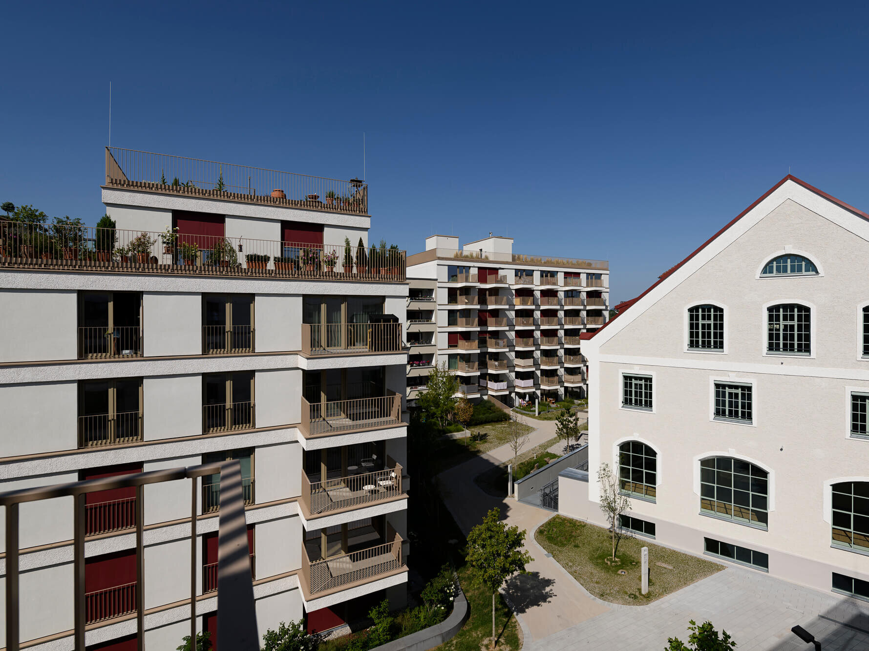 Kuvertfabrik neben Wohngebäuden und Bäumen im Kupa Wohnquartier, München Pasing