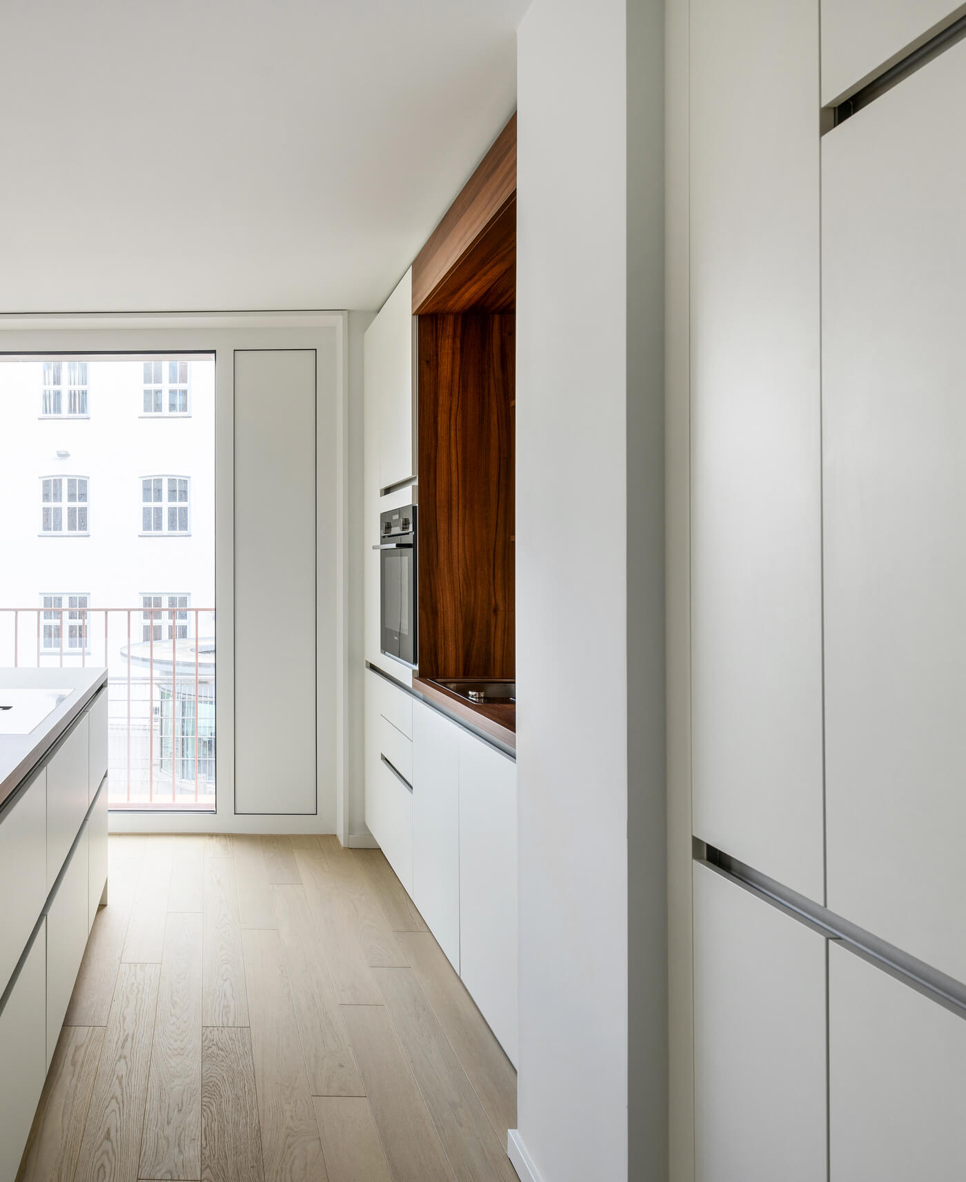 Küche im Van-B-Apartment in München-Schwabing mit Einbaufronten und Holzdetail