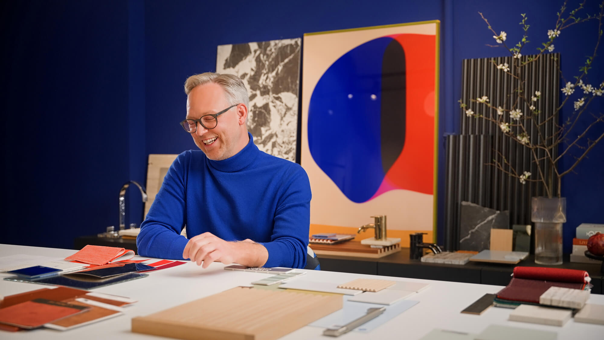 Interior Designer Sebastian Zenker mit Materialmustern in seinem Showroom