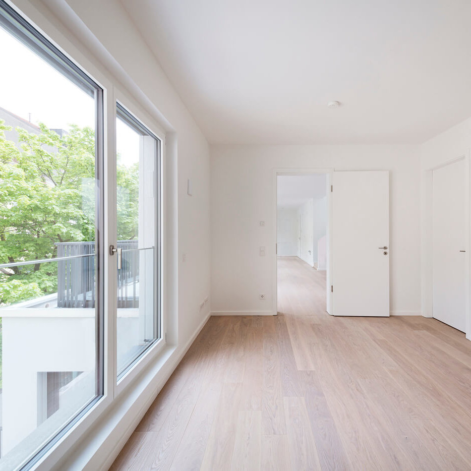 Heller Wohnraum einer Eigentumswohnung im Bereiteranger mit bodentiefen Fenstern und Blick ins Grüne