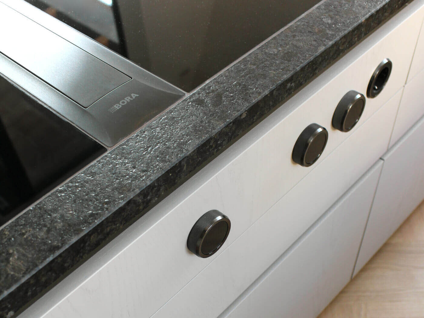 Atelier A.2.8 Detail Küchenzeile mit Kochfeld und Natursteinarbeitsplatte