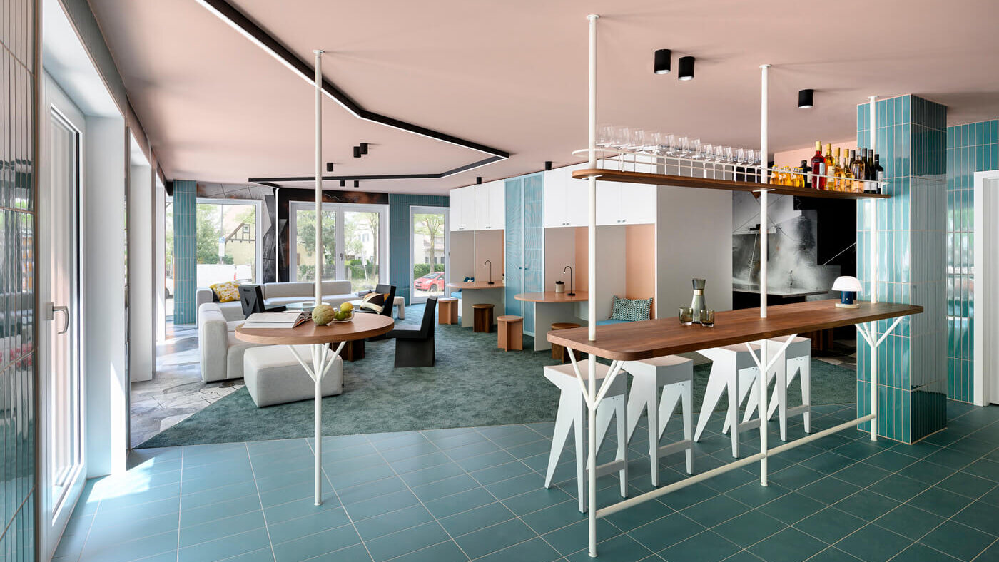 Co-Living-Bereich mit Küche, Sitzbereich und Arbeitsplätzen, Van B München