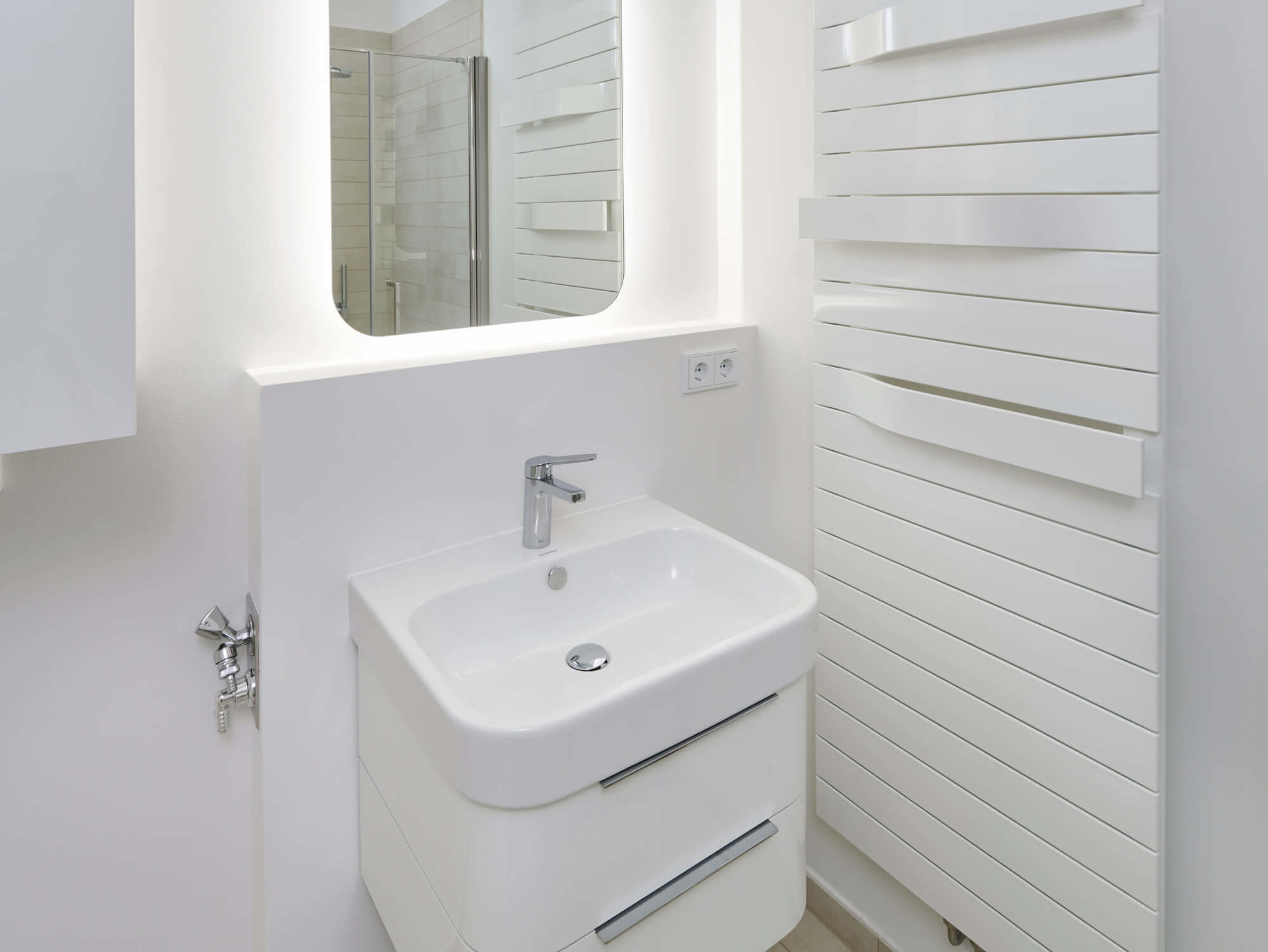 Waschbecken mit Spiegel und Heizung in Wohnung WAVE Berlin-Friedrichshain