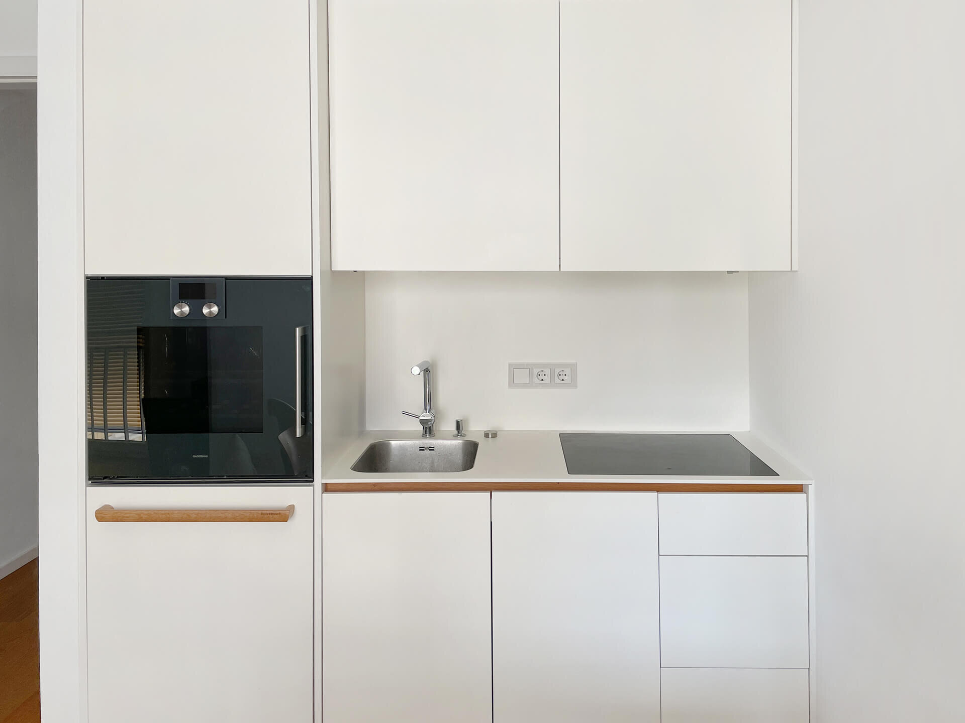 Einbauküche mit weißen Fronten in Wohnung W.33 im Neubau K63, München