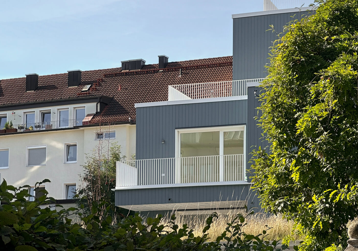 Fassadenansicht des Hofhauses im Neubauprojekt VINZENT in München-Neuhausen mit moderner Architektur und grünem Innenhof