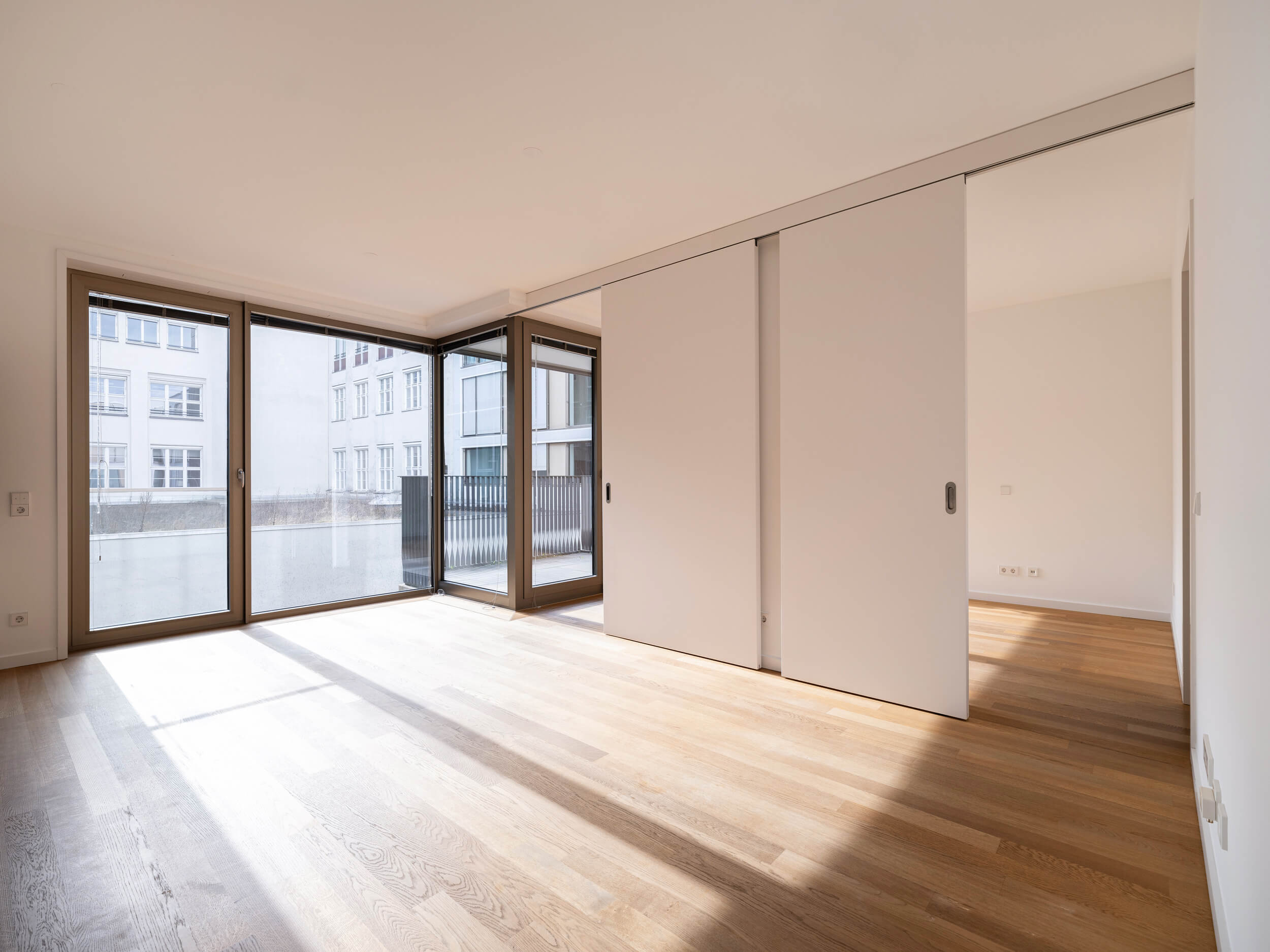Hofstatt Mietwohnung München Altstadt, Wohnraum mit Parkett und Fensterfront