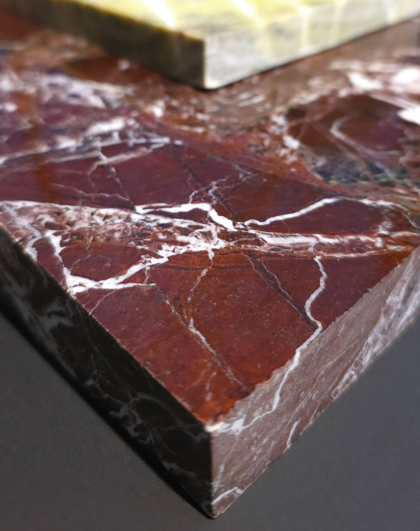 Rötliche Platte aus Feinsteinzeug in Naturstein-Optik mit weißer Maserung