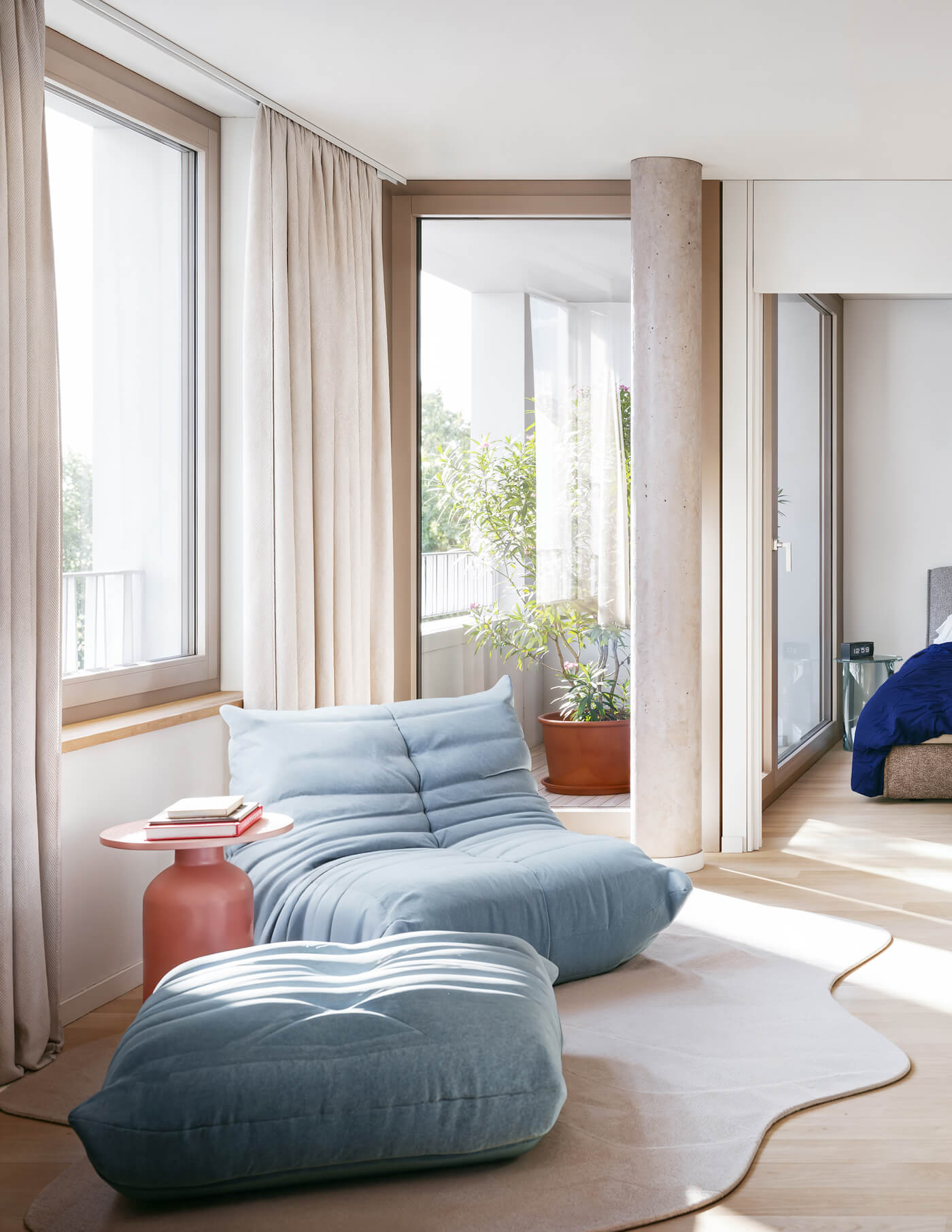 Blauer Sessel am Fenster mit Loggia im Neubauprojekt Haus Claude in Untergiesing