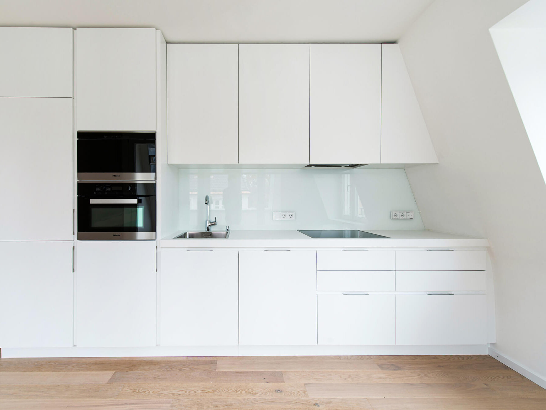 Einbauküche der 3-Zimmer-Wohnung in Bogenhausen mit hellen Fronten und Geräten