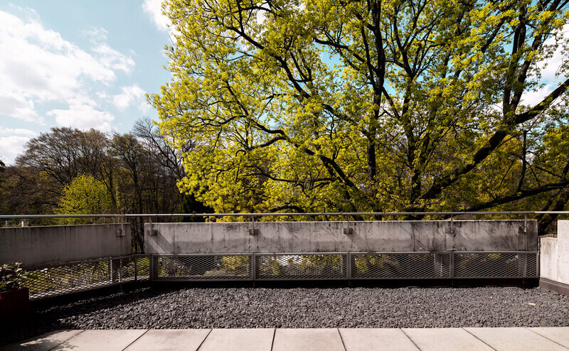 Terrasse vor Bäumen der Wohnung W.10 im Baudenkmal REDUKT in München-Nymphenburg