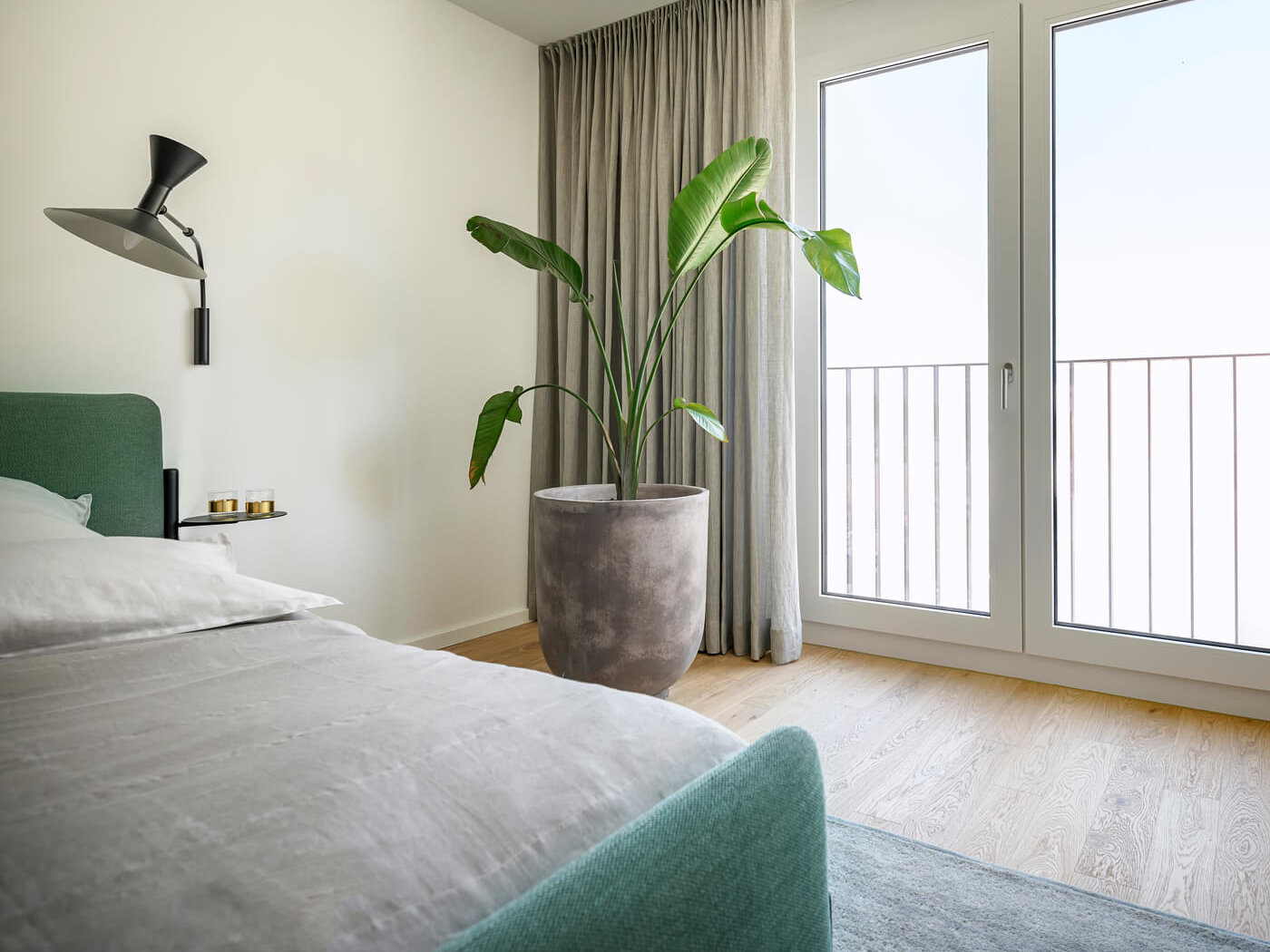 Schlafzimmer der Wohnung D.03 im Haus D des Neubauquartiers kupa in München-Pasing mit Doppelbett, großem Fenster und moderner Einrichtung.