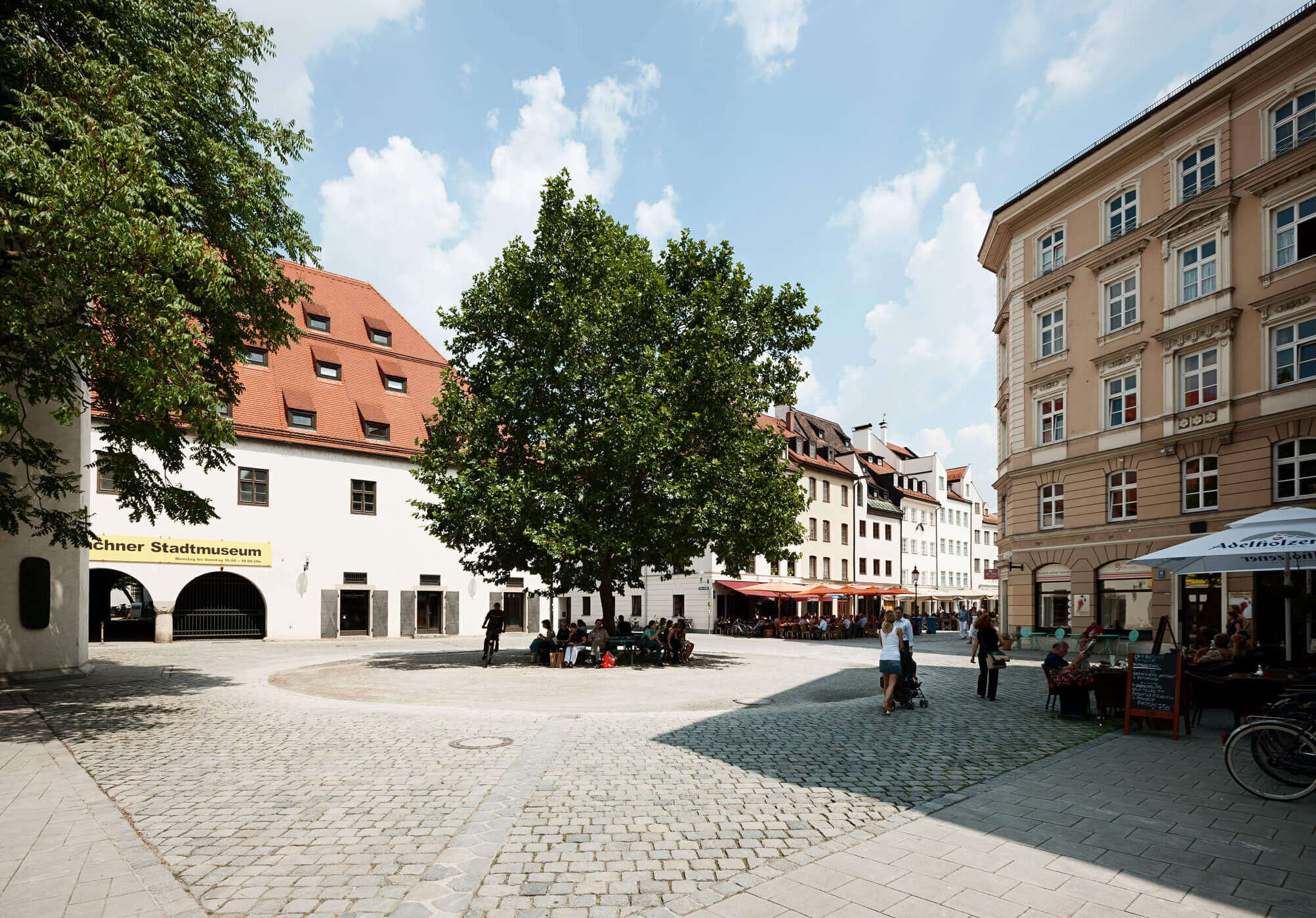 Sebastiansplatz in der Münchner Altstadt mit Stadtmuseum, Baum und Straßencafe
