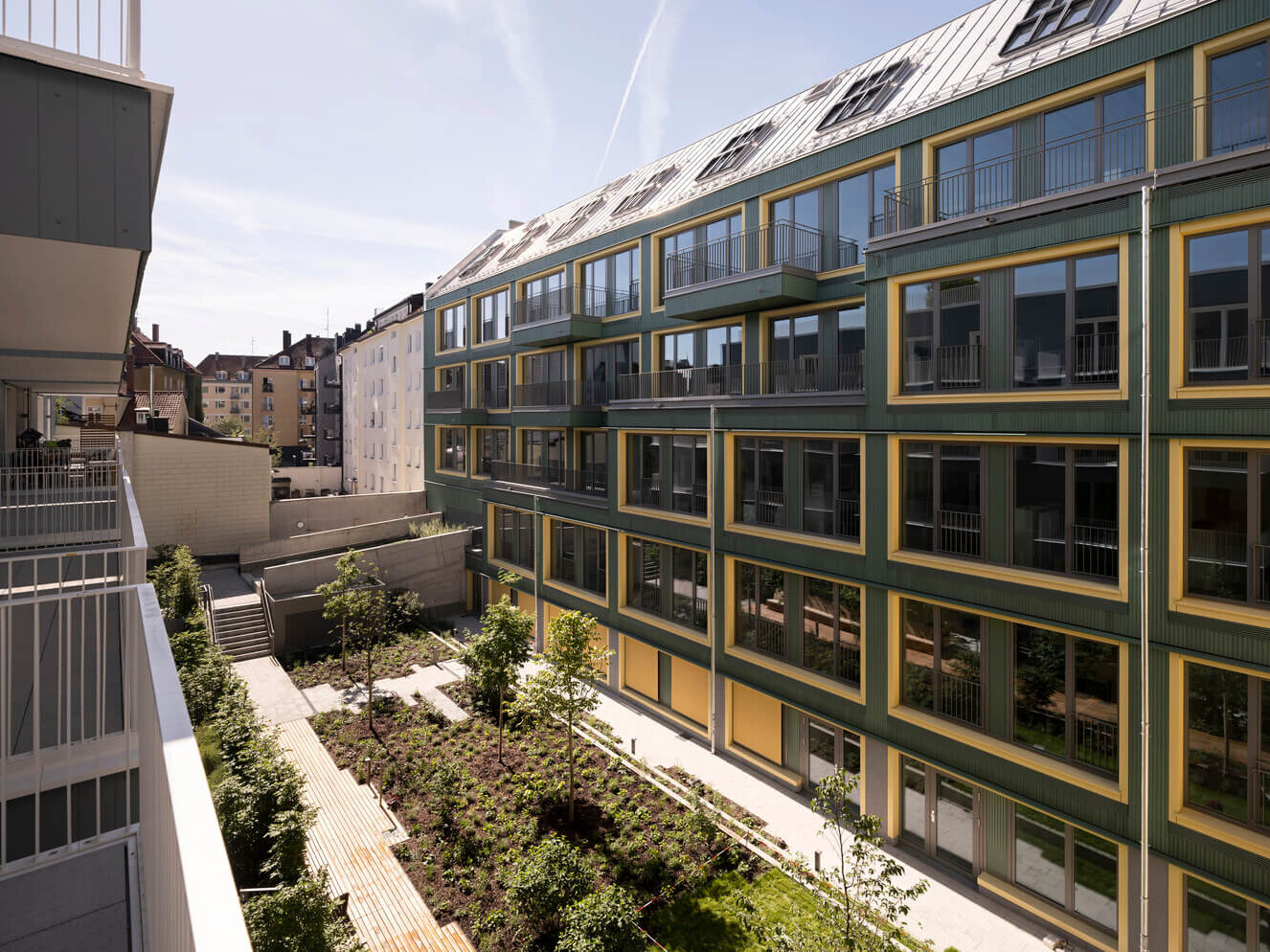 nnenhof mit Fassade und Bäumen im Neubau VINZENT, München Neuhausen