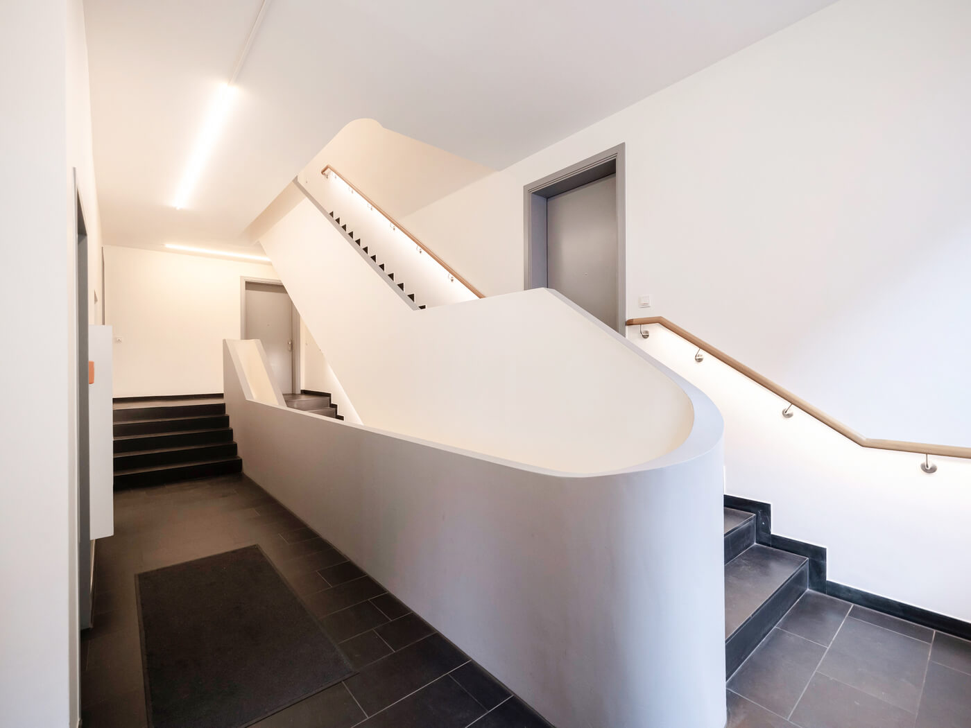 Modernes Treppenhaus am Breiteranger in München-Au mit geschwungener Brüstung.