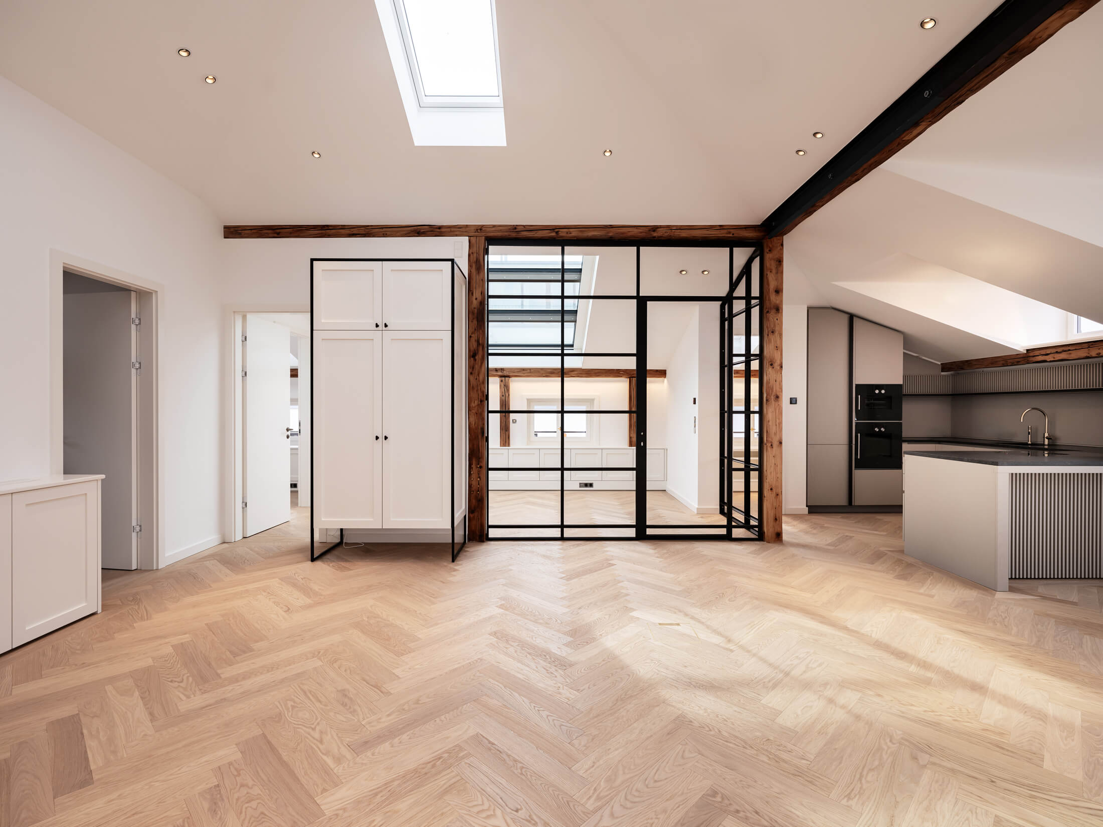 Bürofläche im Ensemble Amalie mit Fischgrätparkett, Glaswänden und offener Küche