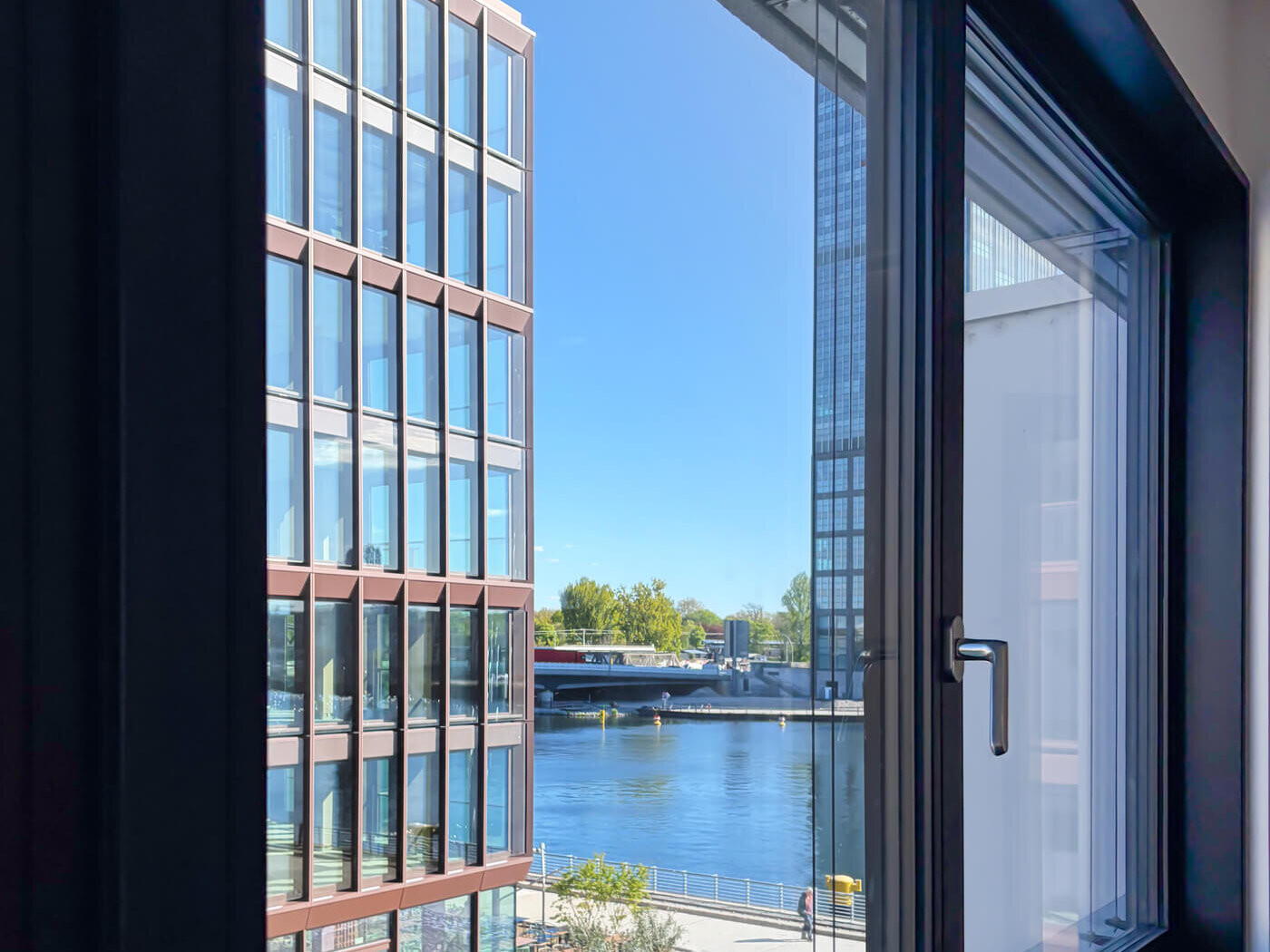 Fenster in Wohnung E.38 mit Blick auf Gebäude und Spree im Neubau WAVE Berlin