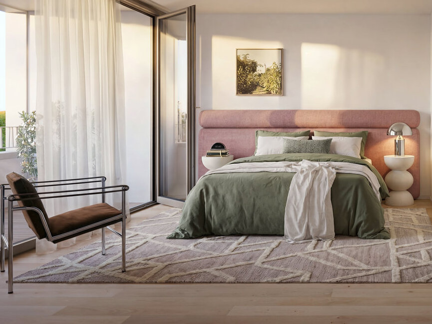 Schlafzimmer mit Bett, Bad und Balkonzugang im Neubau Haus Claude Untergiesing