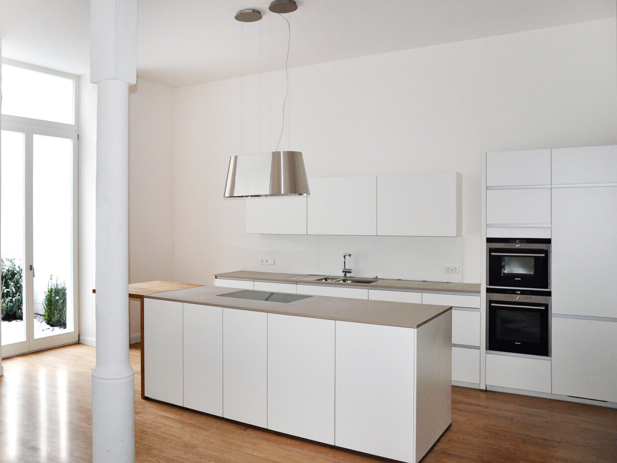 Moderne Einbauküche der Maisonette-Wohnung am Sebastiansplatz mit Kochinsel.