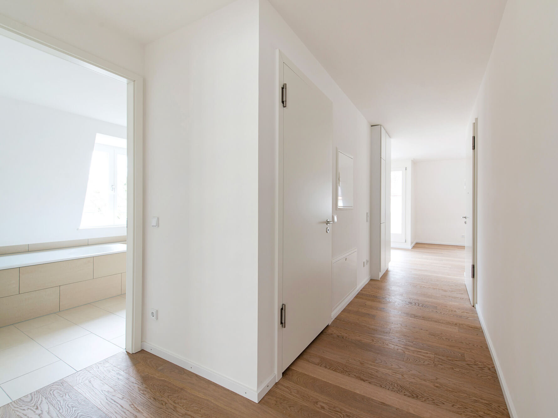 Flur der 3-Zimmer-Wohnung I69 in München Bogenhausen mit Blick ins Bad