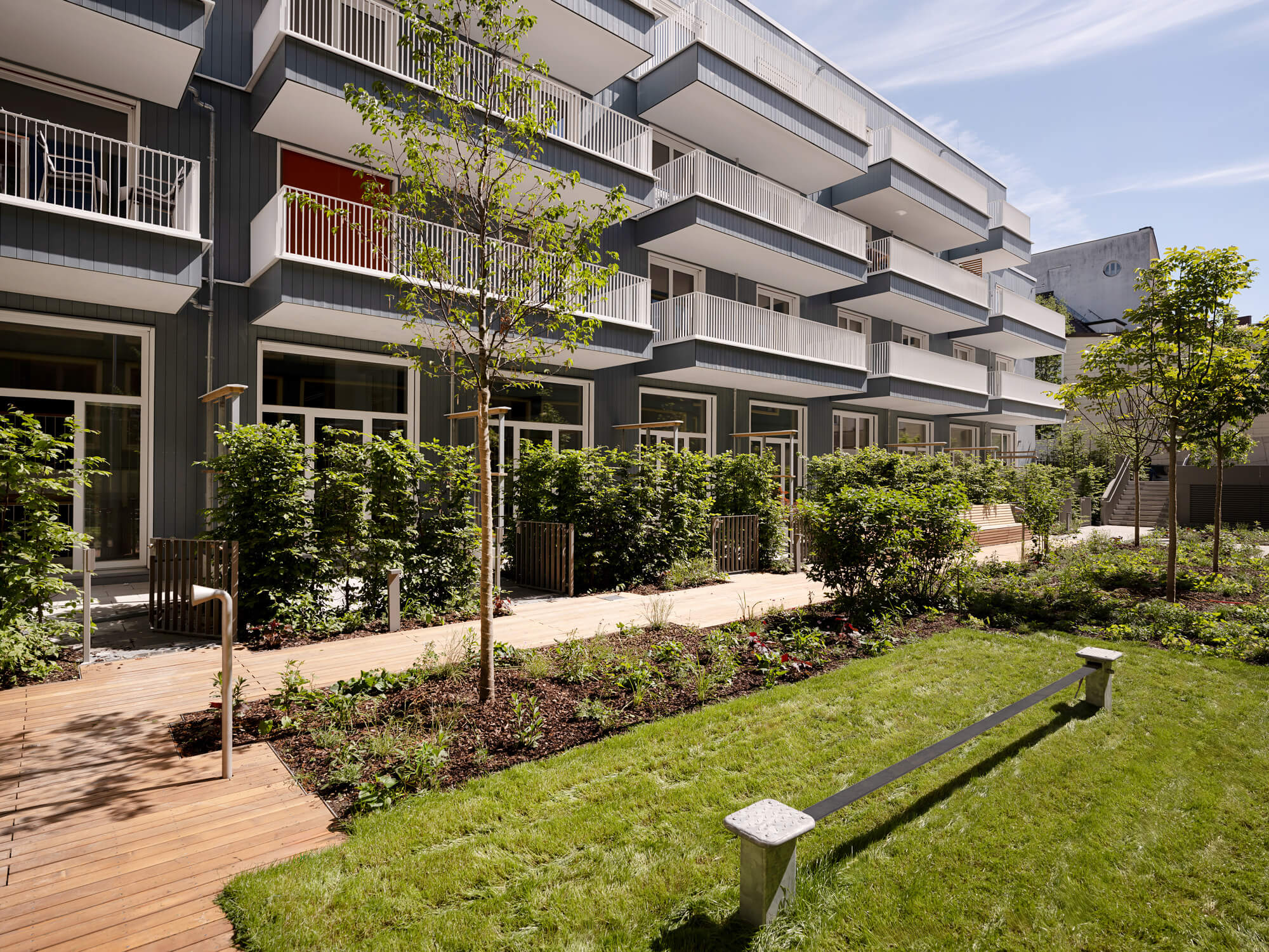 Innenhof mit Fassade und Bäumen im Neubau VINZENT, München-Neuhausen