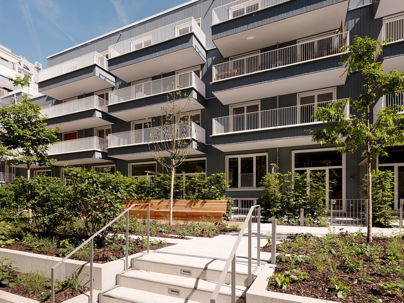 Innenhof mit Fassade und Bäumen im Neubau VINZENT, München-Neuhausen
