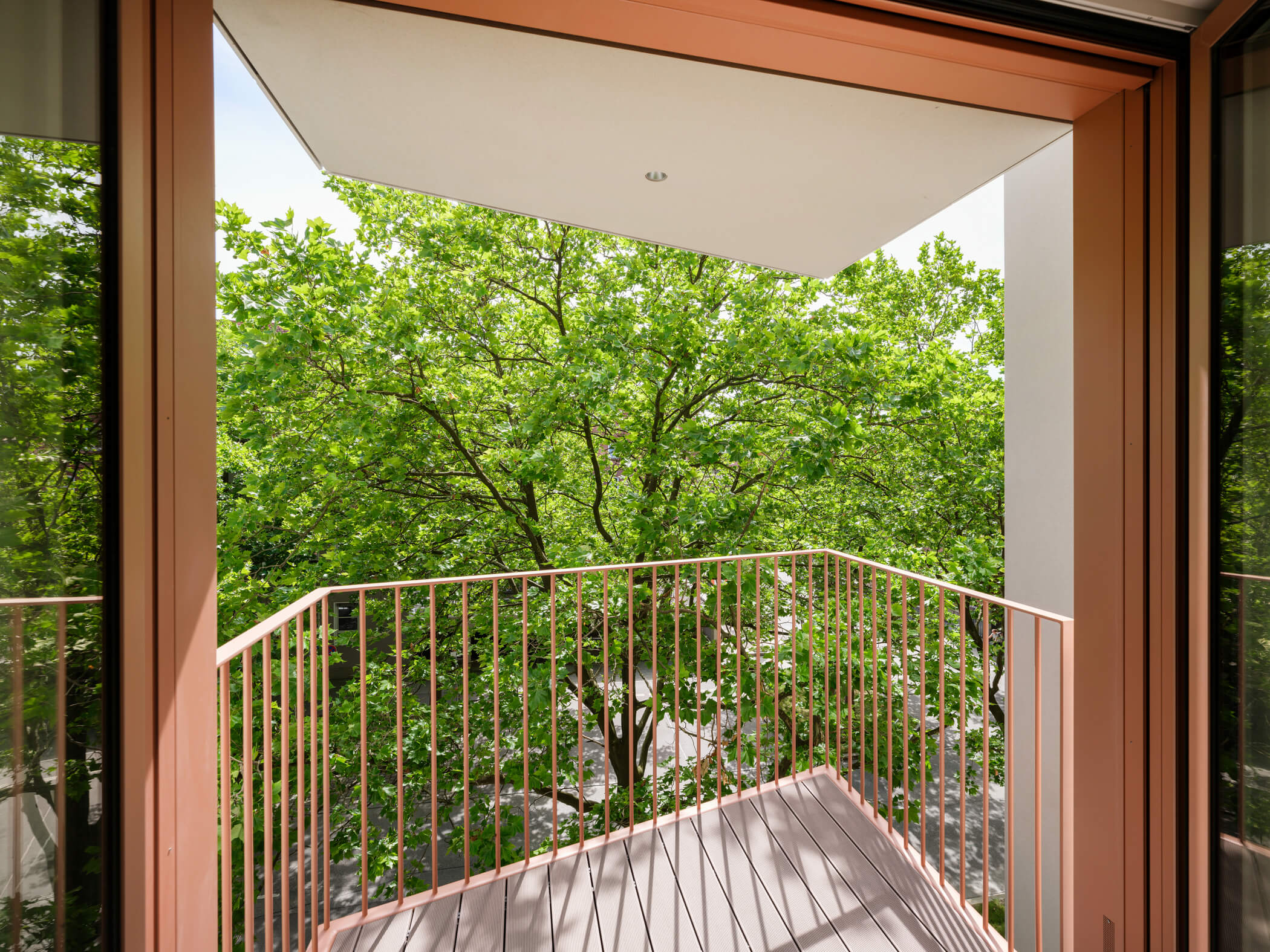 Balkon vor Bäumen in Apartment A.108 im Neubau Van B in München-Schwabing