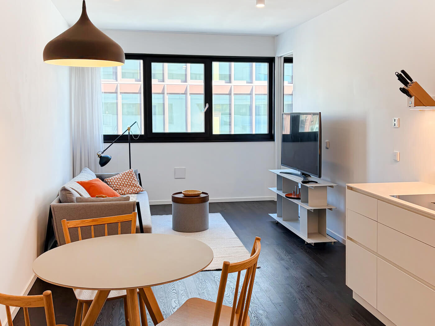 Wohnraum mit Esstisch, Küche und Sofa in Mietwohnung E.38 im Neubau WAVE Berlin