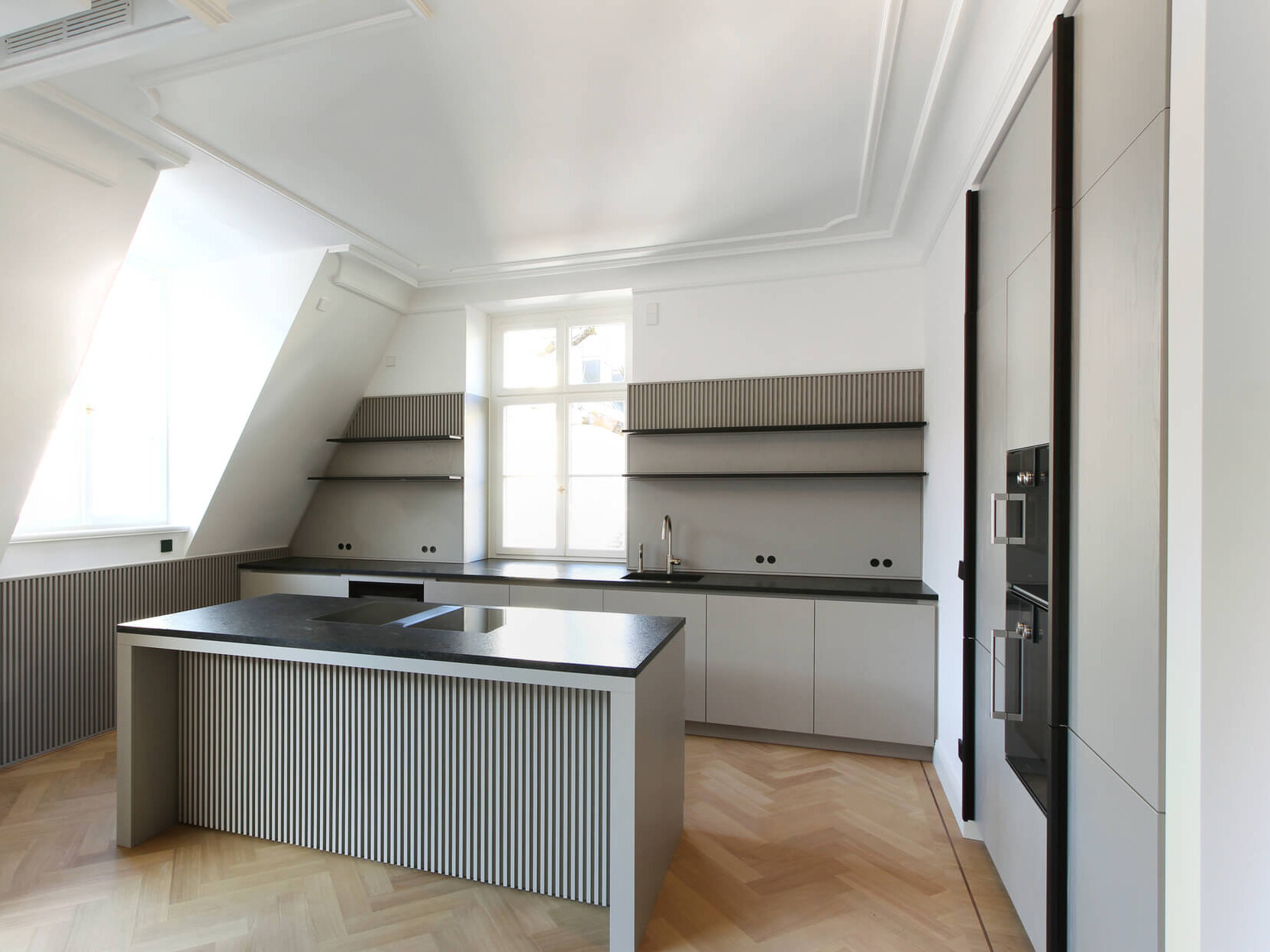 Atelier A.2.8 Maxvorstadt mit grauer Einbauküche, Kochinsel, Geräten und Fenster