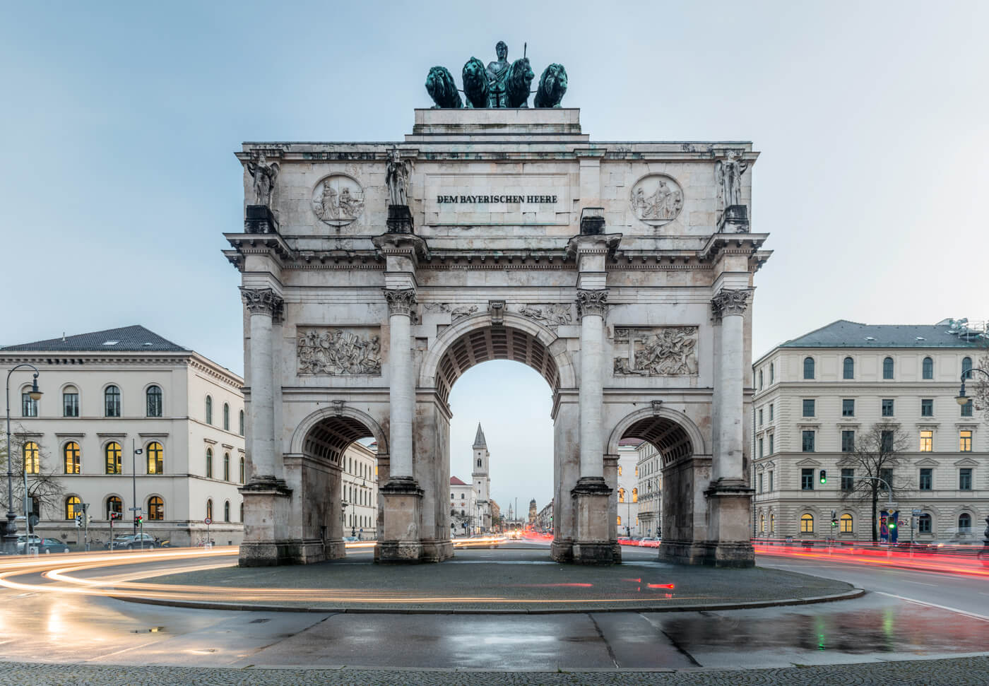 Siegestor in München mit umliegenden Gebäuden und Verkehrsbewegung