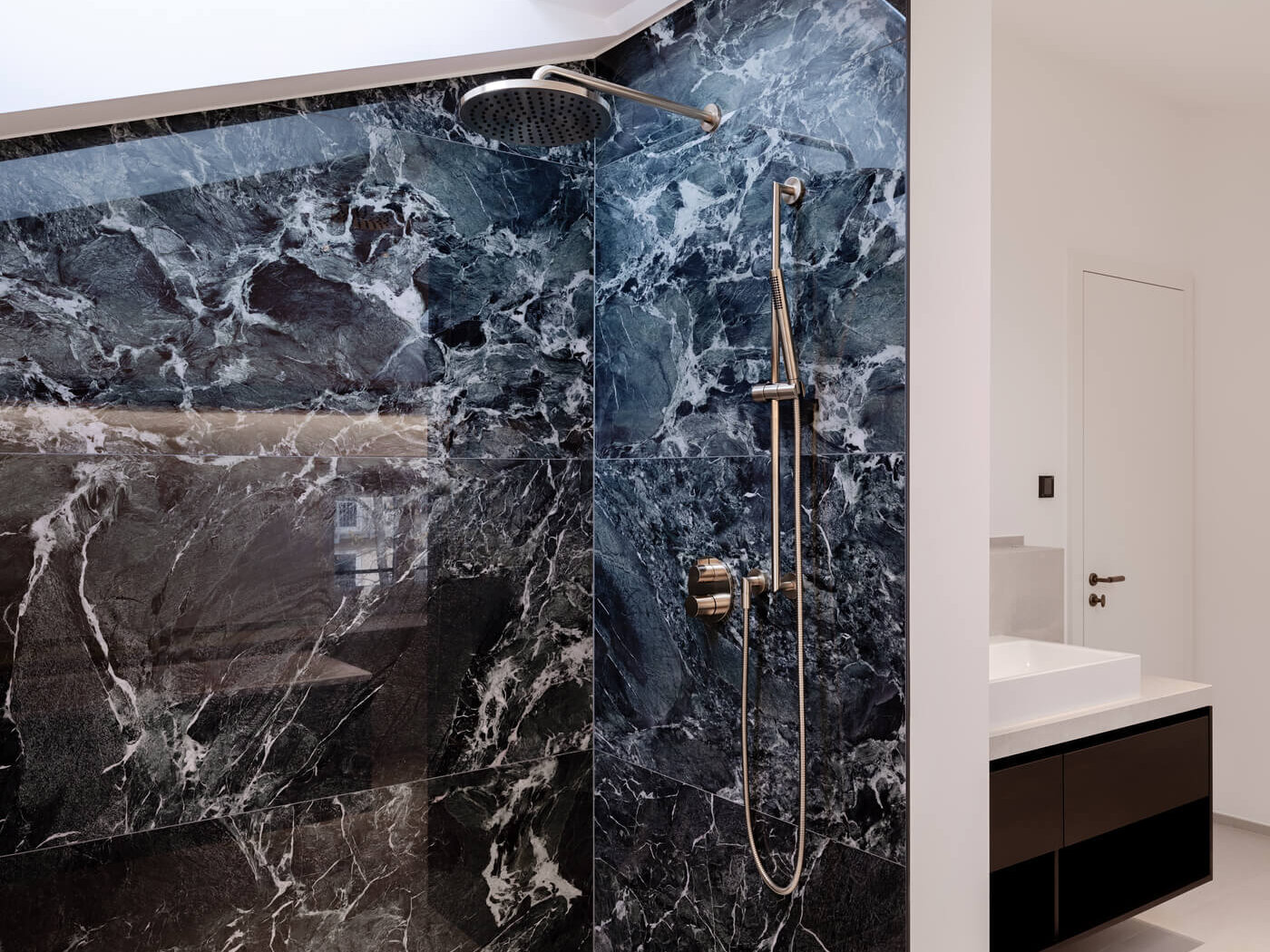 Duschbereich in der Büroeinheit Amalie mit grünen Marmorfliesen und Armatur