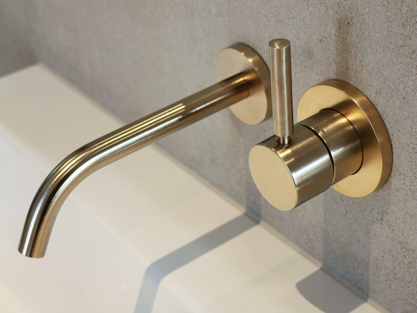 Bad des Atelier A.2.8 mit Waschtisch und Wandarmaturen in Goldto