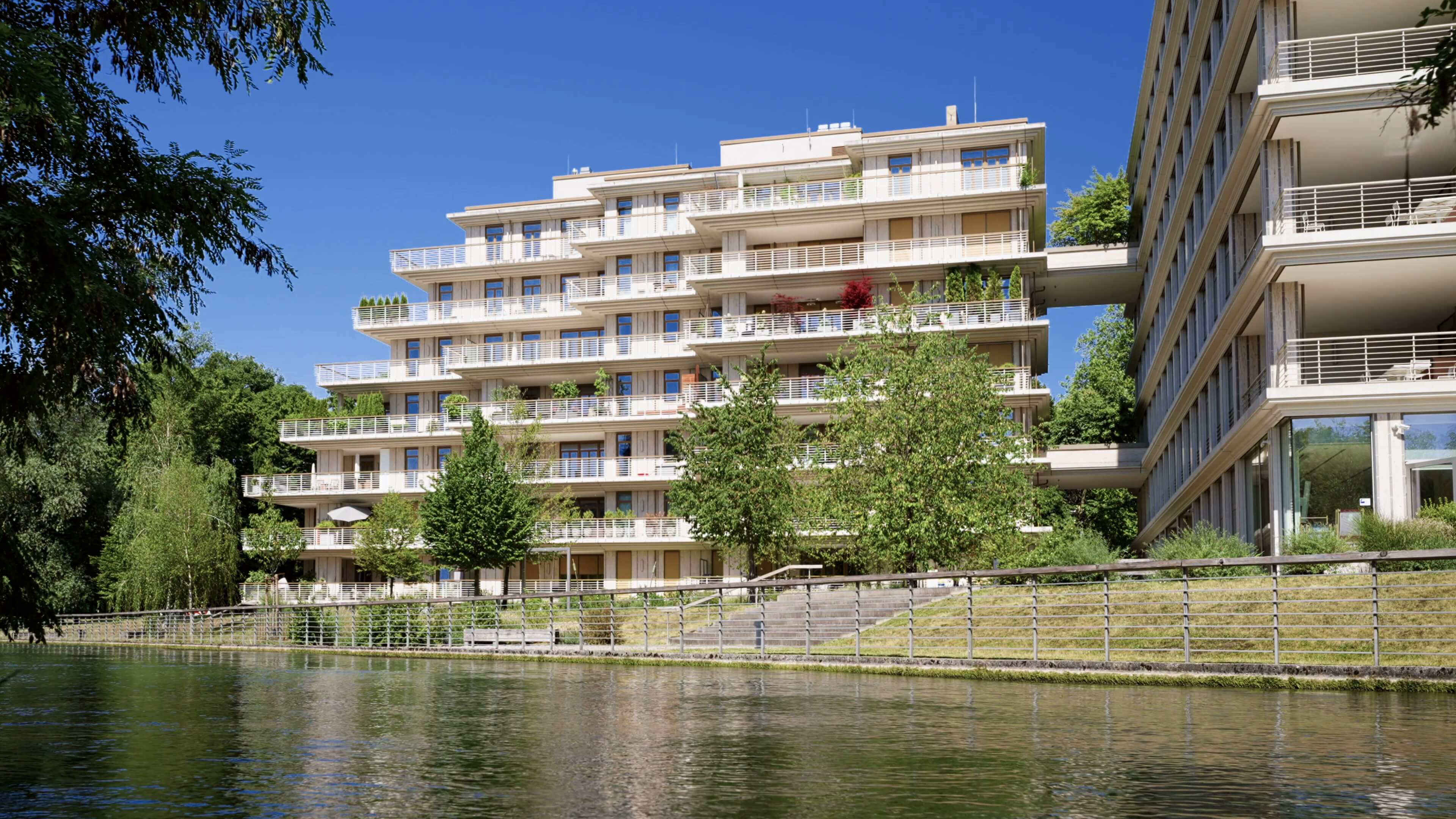 Fassadenansicht des Projekts TIVOLI Garden in München mit terrassierter Architektur direkt am Eisbach im Englischen Garten