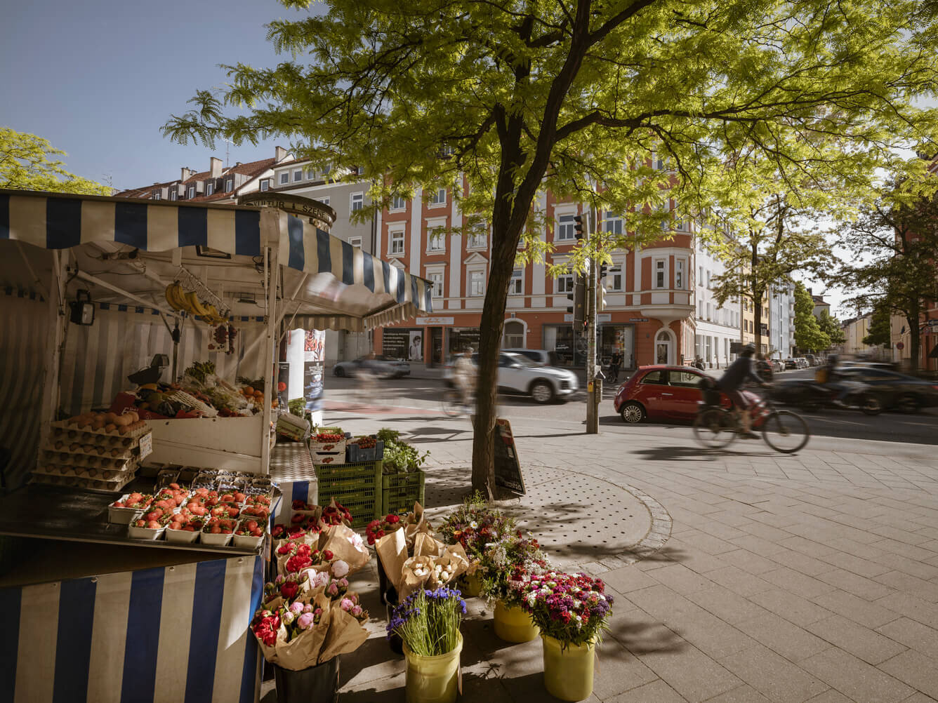 Marktstand mit Blumen und Gemüse auf einem Platz in München