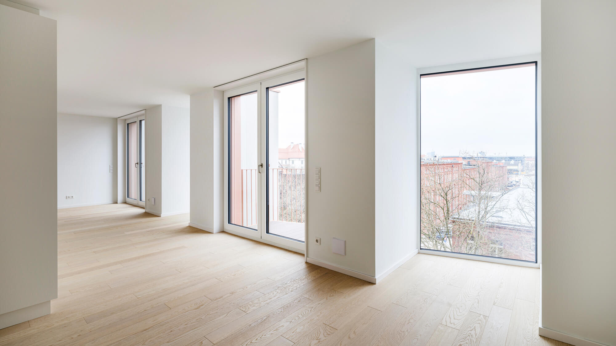 Wohnbereich im Neubauprojekt Van B in München-Schwabing mit bodentiefen Fenstern