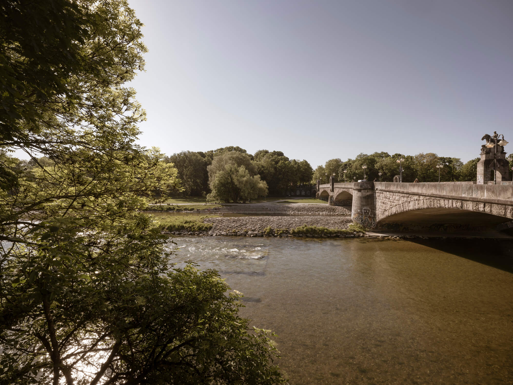 Isarbrücke nahe Haus Claude in Untergiesing mit Flusslauf, Ufergrün &Steinbogen